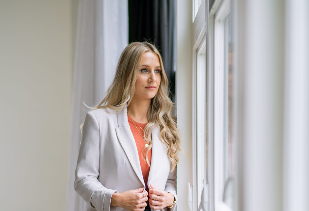 Business owner in a blazer looking confident after strengthening brand credibility and professional branding.