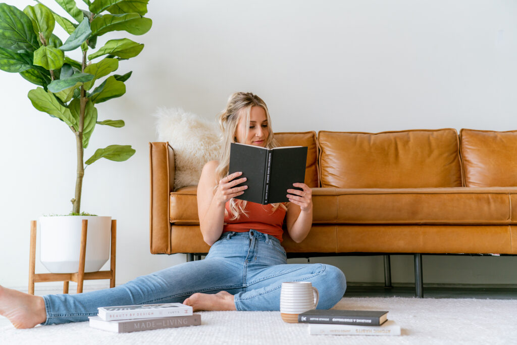 Small business owner reading a book while researching brand positioning and messaging.