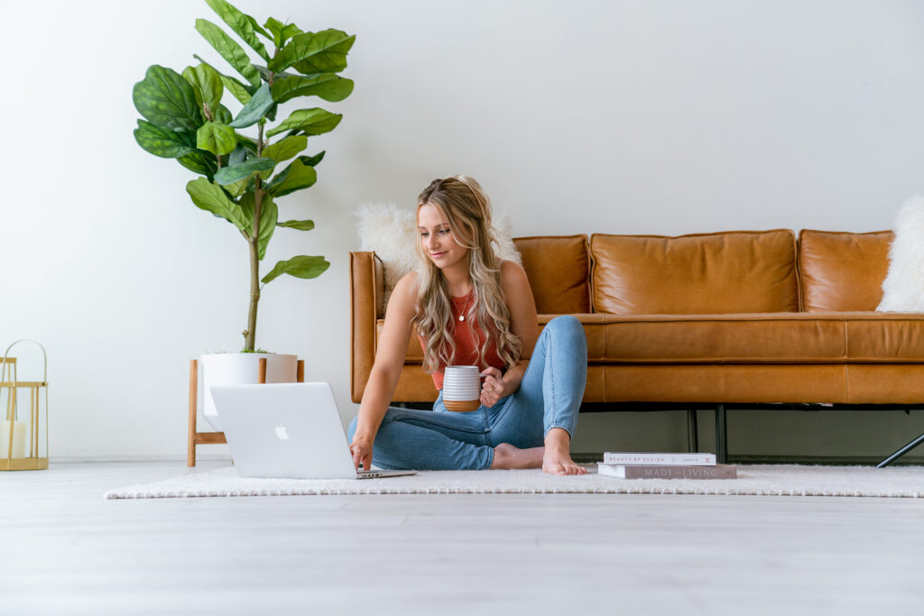 Small business owner reviewing brand strategy notes on a laptop with a coffee mug nearby.