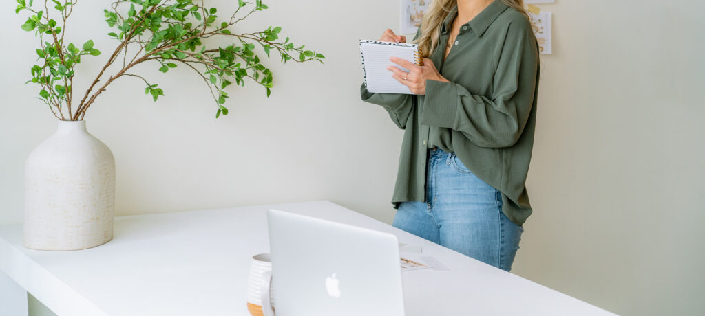 Entrepreneur defining target audience for small business while taking notes at desk