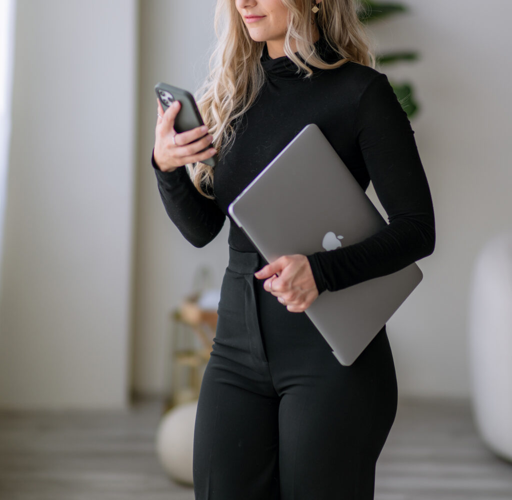 Service business owner using mobile and laptop tools to run her business with the best tools for service business owners