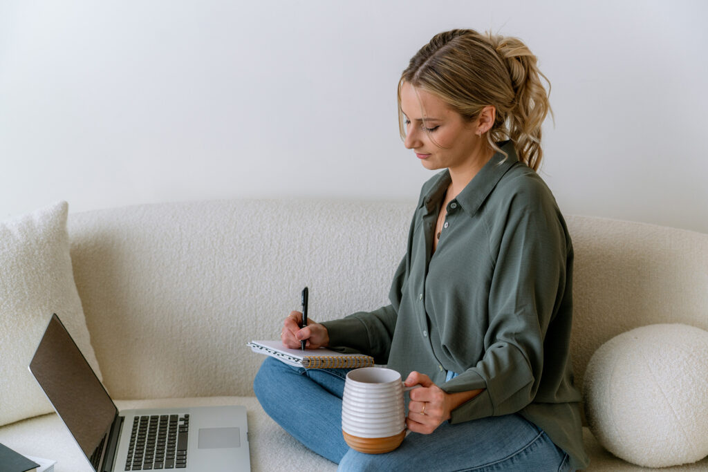 Service business owner planning her workflow with a laptop and notebook using the best tools for service business owners.