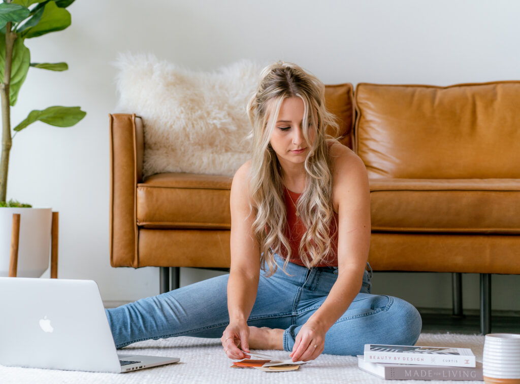Brand refresh vs rebrand planning with laptop, brand samples, and color swatches on the floor.