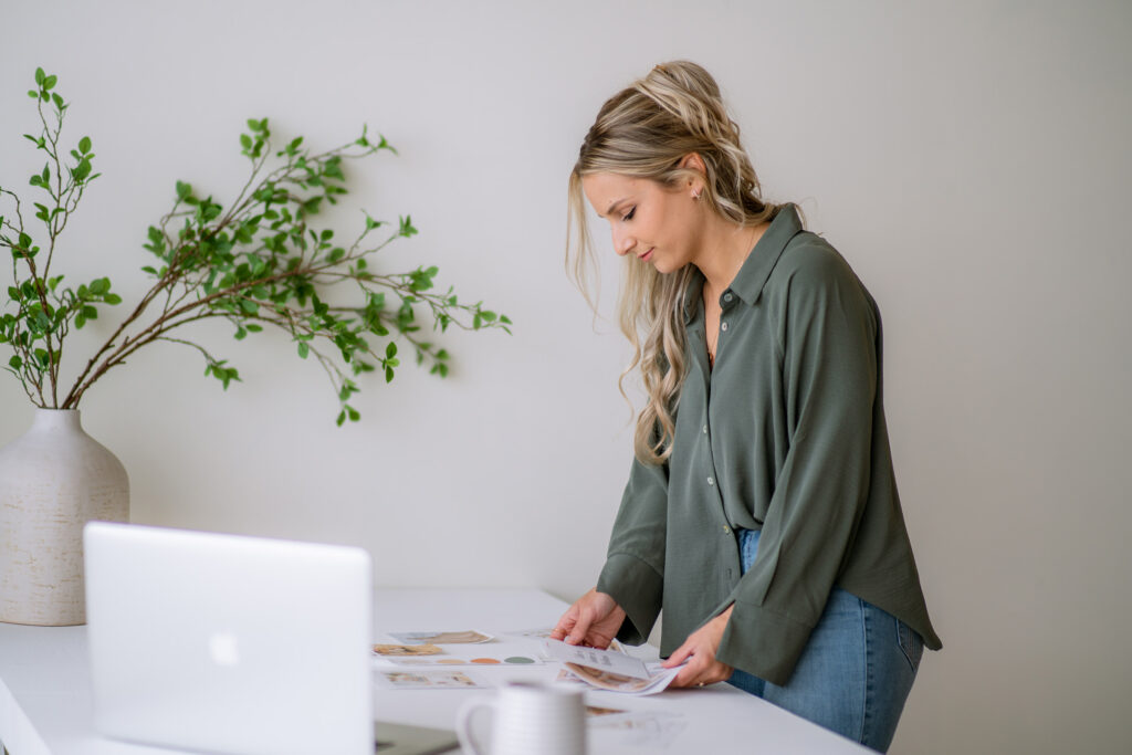Reviewing brand identity materials at a desk to decide between a brand refresh vs rebrand.