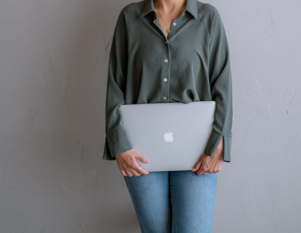Designer holding a closed laptop ready to build a brand identity